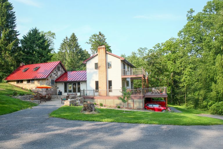 House with red standing seam roof installed by Midstate Roofing LLC